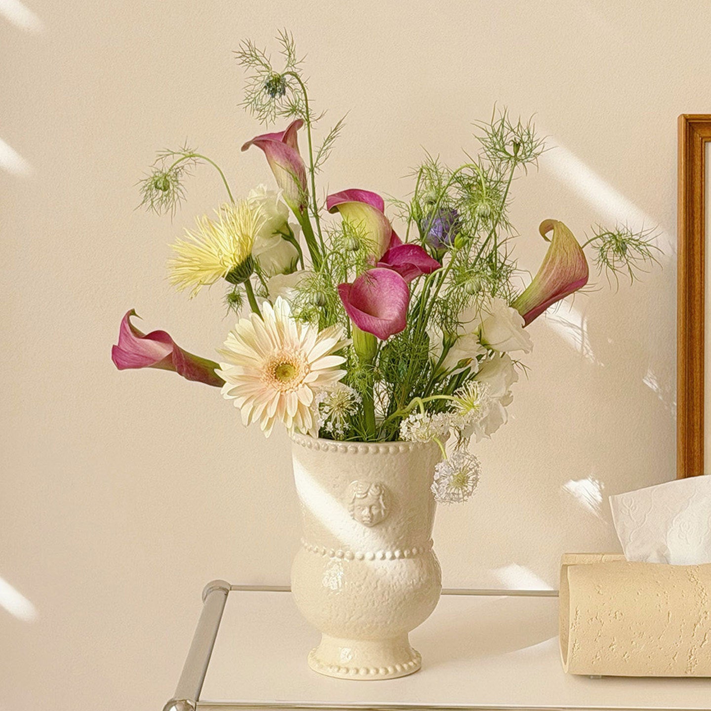 Embossed ceramic urn vase with a flower arrangement