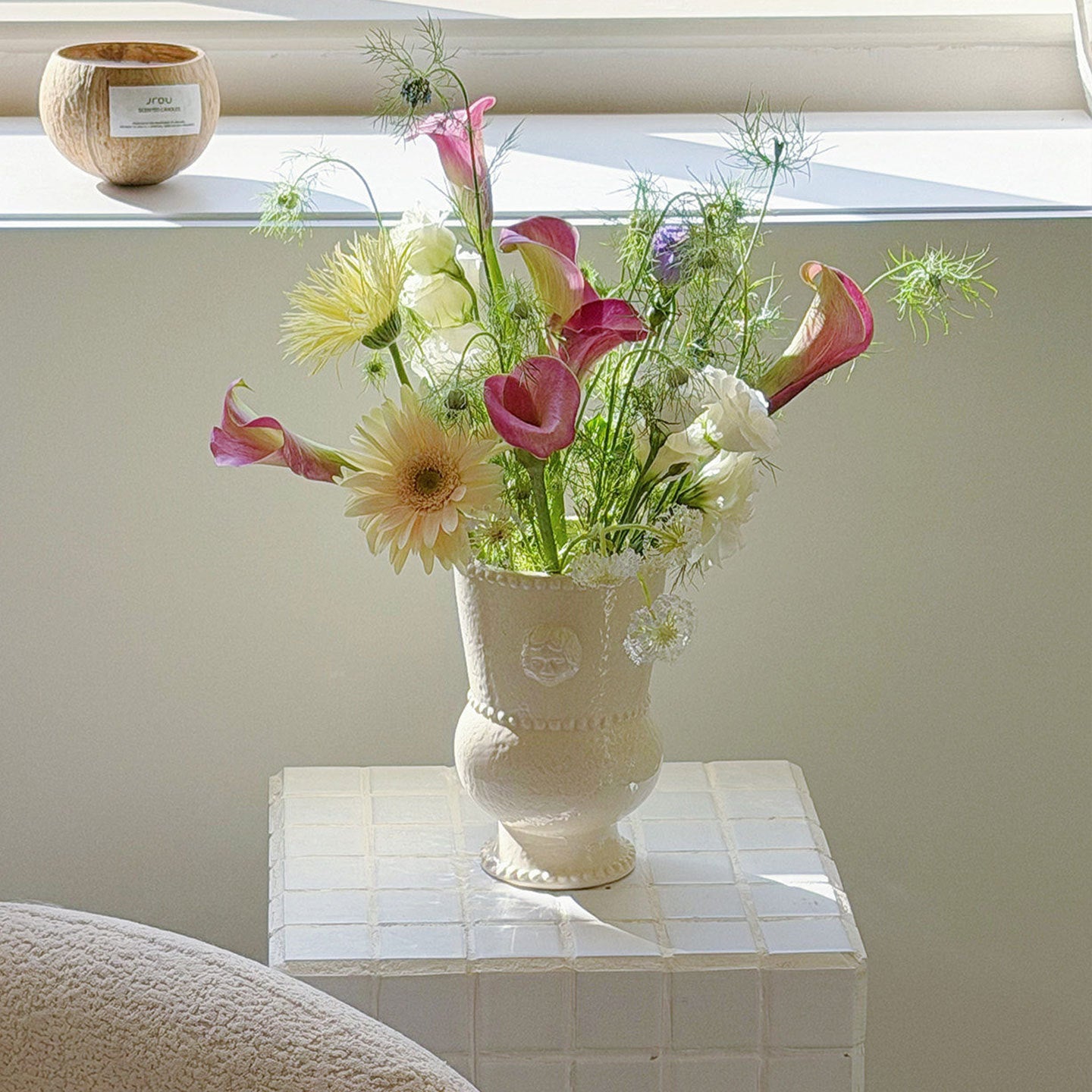 Embossed ceramic urn vase displayed indoors