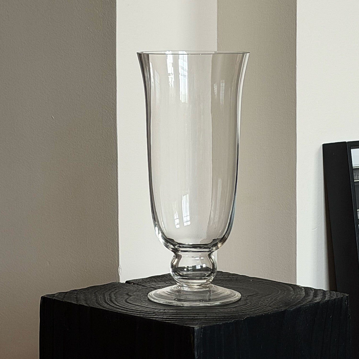 Footed glass flower vase displayed indoors