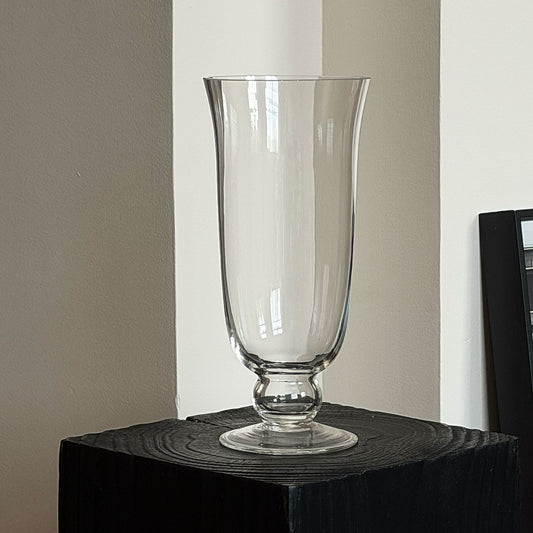 Footed glass flower vase displayed indoors