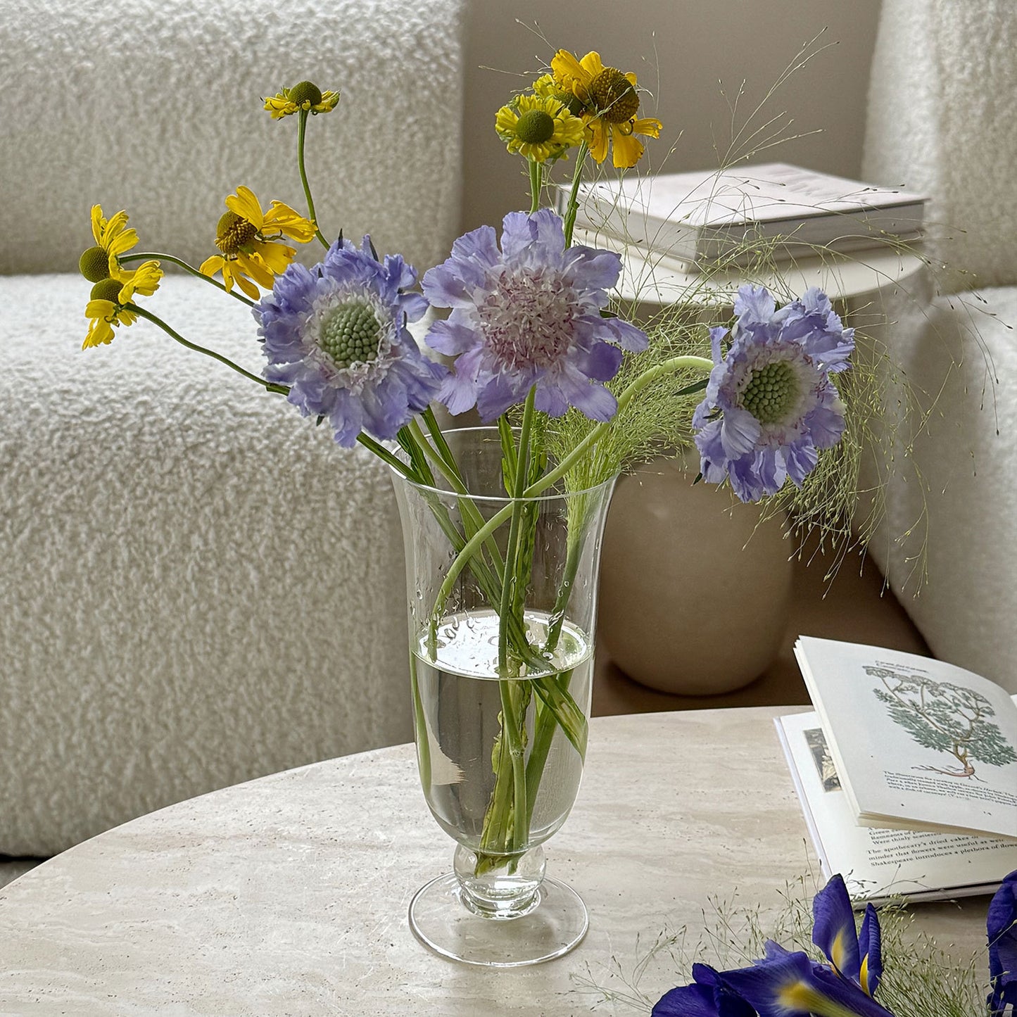 Footed glass vase used for a flower arrangement on a table