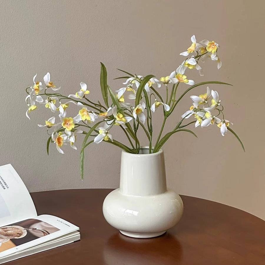 Rounded bulb ceramic vase displayed with flowers on a table