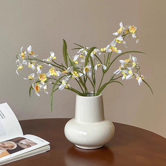 Rounded bulb ceramic vase displayed with flowers on a table