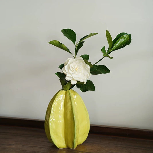 Star fruit shaped ceramic vase with a flower arrangement