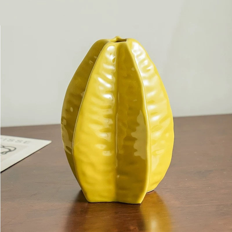 Star fruit shaped ceramic vase displayed on a table