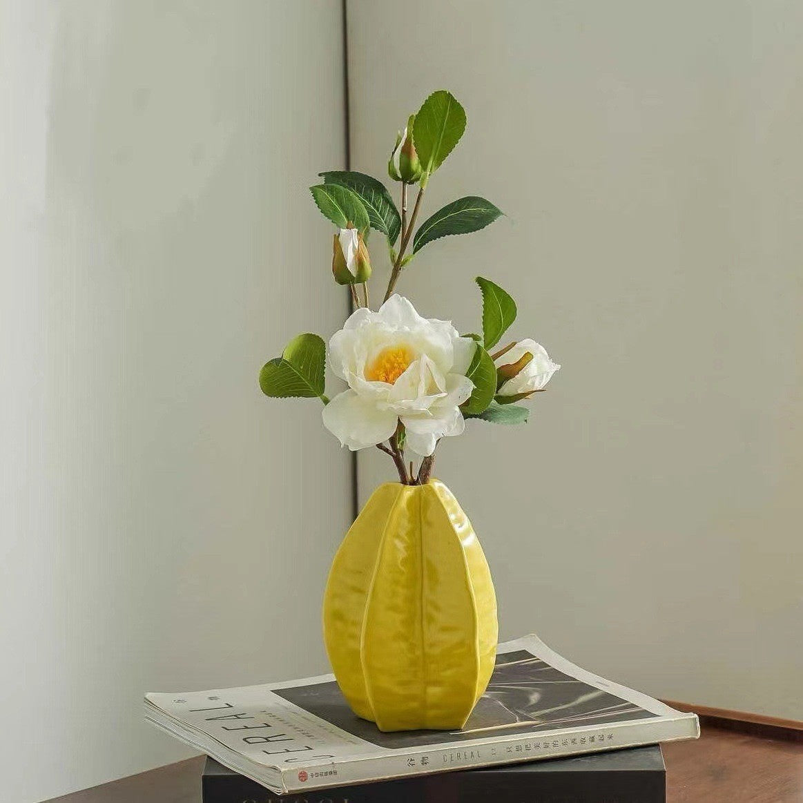 Star fruit shaped ceramic vase displayed with flowers